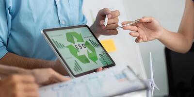 ESG and Sustainability. Professionals discussing ESG strategies with digital tools in a modern office. photo