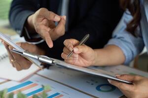 Analyzing Financial Reports. Professionals discussing strategy over charts and documents. photo