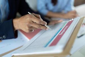 Accounting Review. Business professional analyzing financial data with pen on document. photo