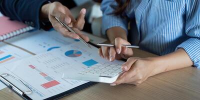Collaborative Financial Discussion. Professionals analyzing data with calculators and spreadsheets. photo