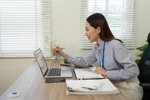 Remote Work and Digital Transformation. Businesswoman smiling while analyzing data on laptop. photo