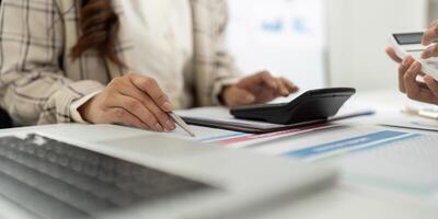 Detailed Financial Analysis. Close-up of accountant's hands working with reports and calculator. photo