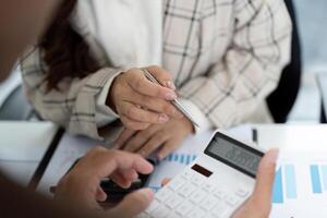 Team Collaboration in Accounting. Colleagues discussing financial data with calculators. photo