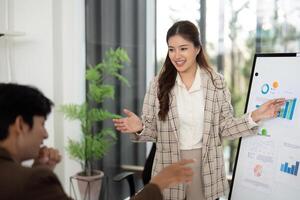 Dynamic Business Presentation. Young woman presenting financial data to a colleague in an office. photo