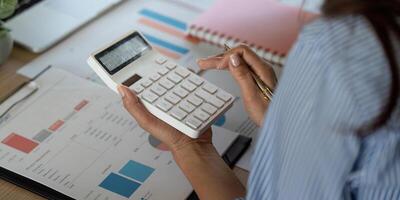 Financial Analysis and Calculation. A woman using a calculator to review business data. photo