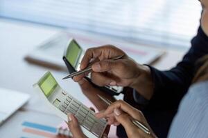 Business Collaboration and Analysis. Professionals discussing financial data with calculator. photo