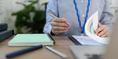 Remote Work and Digital Transformation. Close-up of businesswoman holding pen while analyzing data. photo