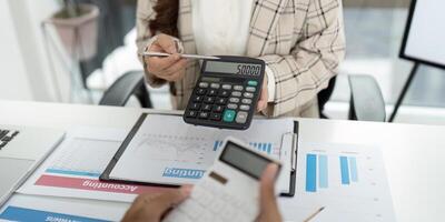 Financial Reporting. Accountant showing calculator display with figures during client meeting. photo