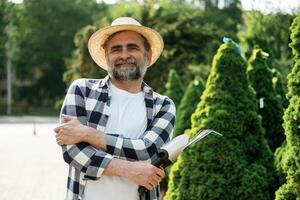 Standing with tools., Senior gardener is at work at daytime photo