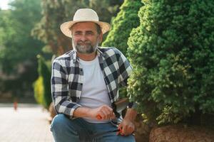 Enjoying the job.,, Senior gardener is at work at daytime photo