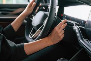 Focused close up view of woman hands ,,that are driving new car photo