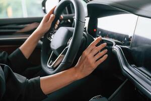 Focused, close, up view of woman hands that are driving new car photo