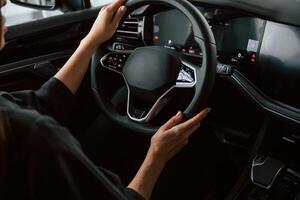 Focused close ,up view of woman hands that are driving new car photo