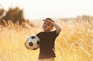 Holding, soccer, ball,,. Little boy is having fun outdoors at summertime photo