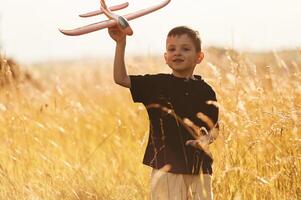 Red colored toy plane, playing.. Little ,boy is having fun outdoors at summertime photo