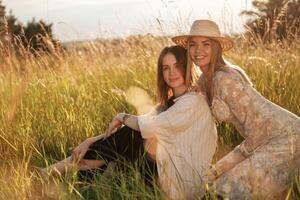 Sitting together. Two ,,women friends are in the rural field photo
