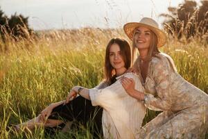 Sitting together. Two women friend,s are ,in the rural field photo