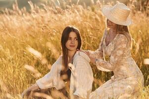 Two women friends are in the rural, field., photo