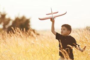 Red colored, toy ,plane, playing. Little boy is having fun outdoors at summertime photo