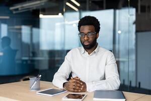 Man listens attentively during a call in a modern office setting, displaying engagement and focus during the virtual meeting photo