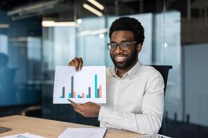 Young professional presenting financial data during an online conference, explaining a graph with colorful columns to his audience photo