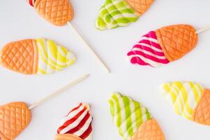 Vibrant and playful summer pattern made of ice cream shaped lollipops on white background. Creative candy concept. Colorful sweet food background. photo