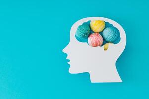 Profile of paper human head with brain containing ice cream on blue background. Conceptual image symbolizing cravings, sweet summer thoughts, or playful mind. Creative background design. Flat lay. photo