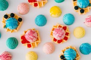 Colorful pattern with waffles, ice cream scoops, raspberries and fresh blueberries on white background. Sweet food concept. Perfect for summer themed designs and playful backdrops. Flat lay style. photo