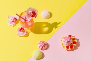 Summer scene with pink tropical drink, orchid flowers, waffle and ice cream scoops on pastel pink and yellow background. Sun and shadows. Cocktail aesthetic concept. Trendy summer party idea. photo