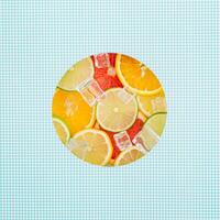 Creative composition with citrus fruits and ice cubes visible through a paper gap. Summer fruit layout. Ideal for concepts related to health, hydration, summer drinks or natural ingredients. Flat lay. photo
