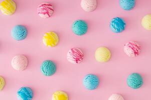 Colorful pattern composition made of various ice cream scoops on pastel pink background. Minimal summer concept. Trendy sweet dessert idea background. Ice cream aesthetic backdrop. Flat lay style. photo