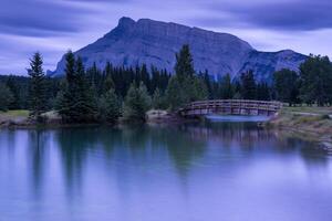A bridge over a lake and mountains in the background photo
