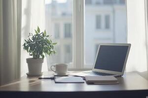 Modern minimalistic desk setup featuring a laptop, coffee, plant, and notebook in a bright home office with natural light photo