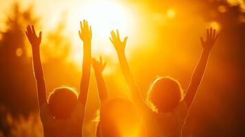 Happy children celebrating together in a bright outdoor setting, raising hands in excitement during a sunny afternoon photo