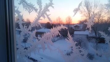 Frost patterns etched on a winter window reveal a breathtaking sunrise over a snowy landscape photo