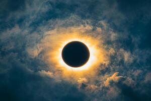 Dramatic solar eclipse shadows clouds with radiant sunlight creating a breathtaking halo in the sky photo