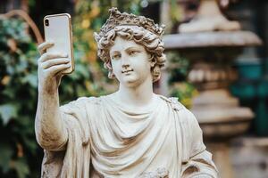 Vintage stone statue captures a selfie with a smartphone in a lush garden setting, bridging old and new artistic expressions photo