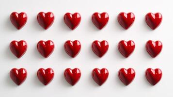 Small red hearts arranged in neat rows create a clean and cheerful pattern on a bright white background, ideal for festive occasions or decoration photo