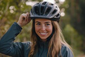 Young woman puts on a bicycle helmet while smiling joyfully outdoors in sportswear before her cycling adventure photo