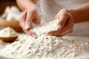 Anonymous woman preparing flour for kneading in a kitchen while sprinkling it over a pile of flour on a countertop photo