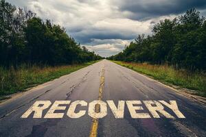 Hopeful recovery path on an empty road under an overcast sky stretches into the distance surrounded by nature photo
