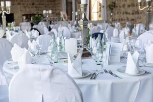 Elegant dining setup in a luxurious venue for a special event surrounded by stone walls and beautiful decor photo