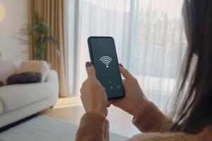 Woman checking WiFi connection on smartphone while seated in cozy indoor environment with natural light photo