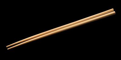 Simple wooden chopsticks resting on a dark surface showcasing traditional Asian dining utensils photo