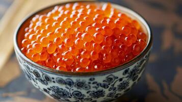 Fresh salmon roe served in an elegant patterned bowl, showcasing its vibrant color and texture photo