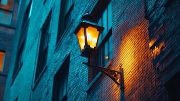 Vintage street lamp illuminates the warm glow on an old brick building in the city at dusk photo