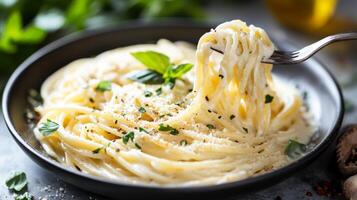 Delicious spaghetti topped with herbs and cheese served in a bowl on a table photo