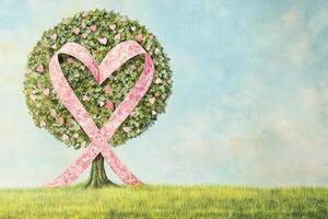 Heart-shaped tree with pink ribbons and green foliage symbolizes hope and love in a serene landscape photo