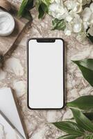Elegance of simplicity with a blank smartphone amidst lush greenery and calming textures on a marble surface photo