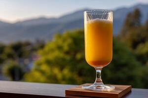 Golden drink on a terrace overlooking misty mountains photo